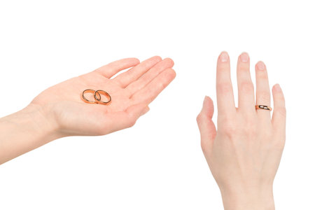 Two golden rings in a woman hand isolated on a white background. Wedding concept.の写真素材