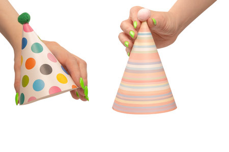 Colorful birthday cap in woman hands isolated on a white backgroundの写真素材