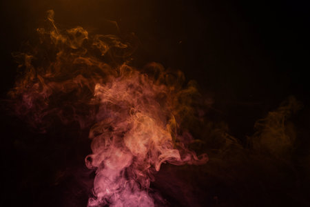 Yellow and pink steam on a black background. Copy space.