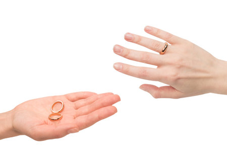 Two golden rings in a woman hand isolated on a white background. Wedding concept.の写真素材