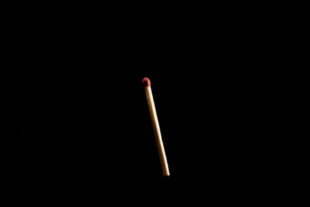 Lit and falling match on a black background.