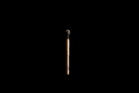 Lit and falling match on a black background.の写真素材