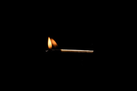 Lit and falling match on a black background.の写真素材