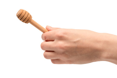 Honey dipper in woman hand isolated on a white background.の写真素材