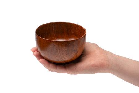 Female hand is holding a wooden bowl isolated on a white background.の写真素材