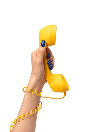 Yellow handset in woman hand isolated on white. Copy space.の写真素材