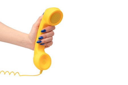 Yellow handset in woman hand isolated on white. Copy space.の写真素材