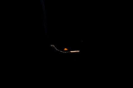 Lit and falling match on a black background.の写真素材