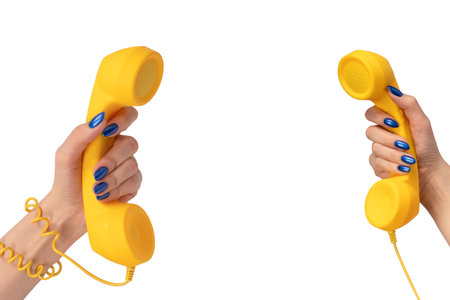 Yellow handset in woman hand isolated on white. Copy space.の写真素材