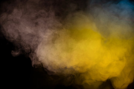 Blue and yellow steam on a black background.の写真素材