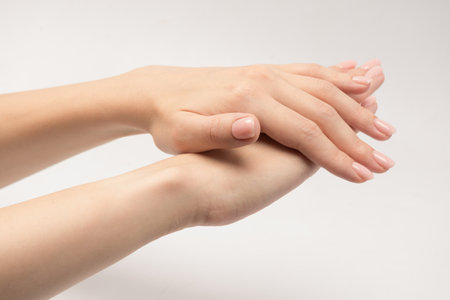 Woman hands with nude manicure isolated on a white background.の写真素材