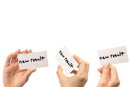 New mindset - new result text on a card in a woman hand isolated on a white background.の写真素材