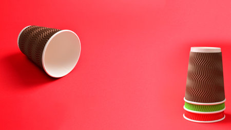 Brown paper cup on a red background. Copy space.の写真素材