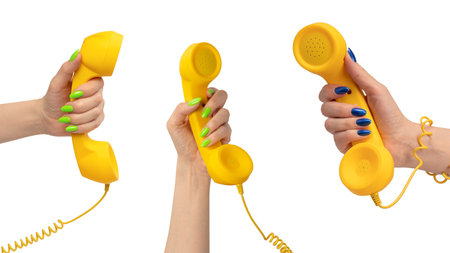 Yellow handset in woman hand isolated on white. Copy space.の写真素材