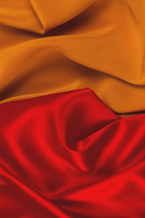 Red and orange silk or satin luxury fabric texture can be used as abstract background. Top view.の写真素材