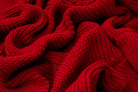 Red sweater texture as a background. Top view