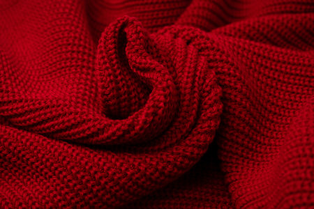 Red sweater texture as a background. Top view