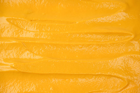 Yellow sauce splashes as a background. Top view.の写真素材
