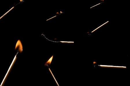 Lit and falling match on a black background.の写真素材