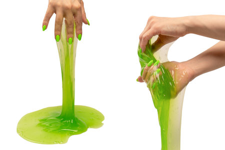 Green slime in woman hand with green nails isolated on a white background.