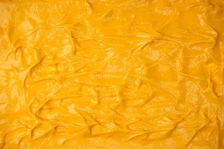 Yellow sauce splashes as a background. Top view.