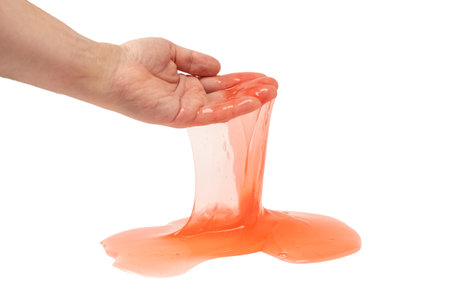 Red slime toy in man hand isolated on white. Top view.