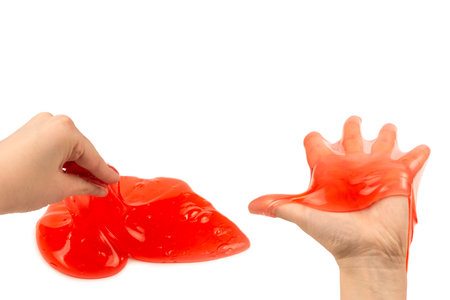 Red slime toy in woman hand isolated on white. Top view.の写真素材