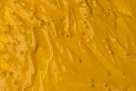 Yellow sauce splashes as a background. Top view.