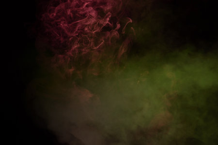 Yellow and pink steam on a black background. Copy space.の写真素材