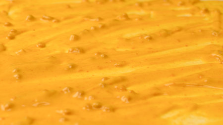 Yellow sauce splashes as a background. Top view.の写真素材