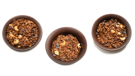 Chocolate granola cereal with nuts in a bowl background. Isolated on white background.の写真素材