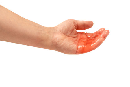 Red slime toy in man hand isolated on white. Top view.の写真素材