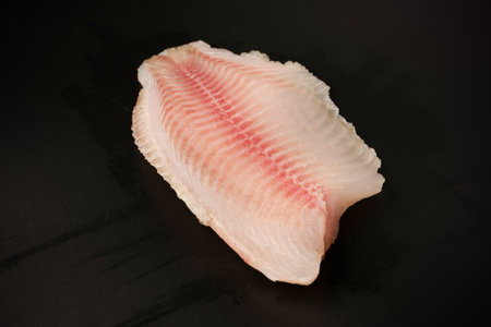 Fresh tilapia fillet on black background, top view.の写真素材