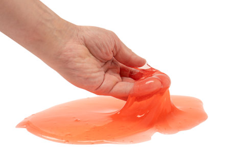 Red slime toy in man hand isolated on white. Top view.の写真素材