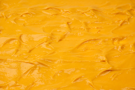 Yellow sauce splashes as a background. Top view.の写真素材