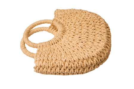 A beige straw bag isolated on a white background.の写真素材