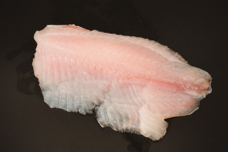 Fresh tilapia fillet on black background, top view.の写真素材