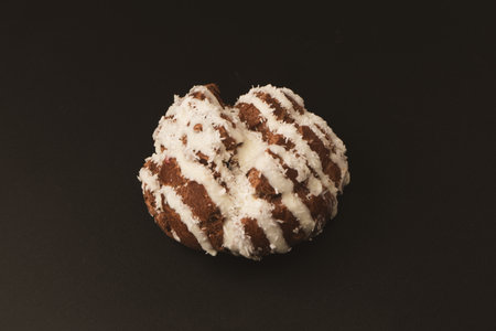 Profiteroles with coconut cream on a black background.