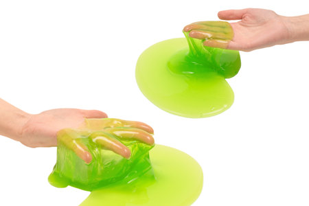 Green slime toy in woman hand isolated on white background.の写真素材
