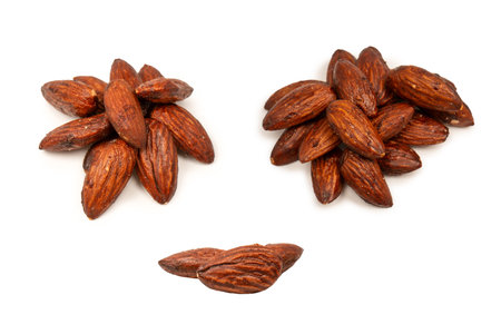 A group of caramelized almonds isolated on a white background.の写真素材