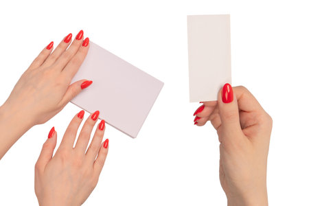 A notebook with empty white paper in woman hands with red nails. Copy space.の写真素材