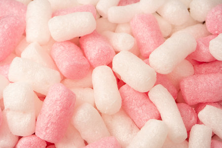 Pink and white box filler as a background. Top view.