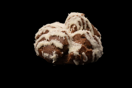 Profiteroles with coconut cream on a black background.