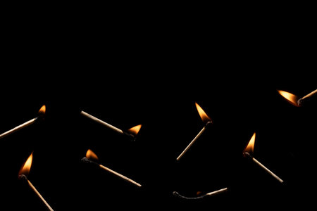 Lit and falling match on a black background.