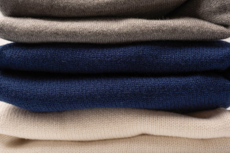 A group of warm sweaters isolated on a white background. Stack of folded sweaters on white...