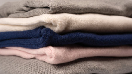 A group of warm sweaters isolated on a white background. Stack of folded sweaters on white...