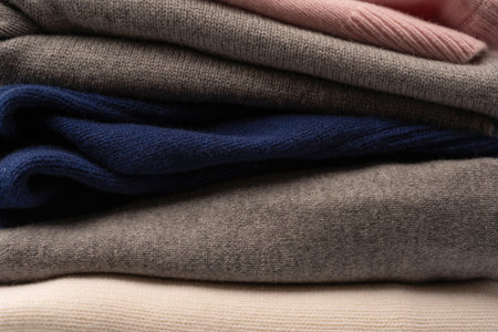 A group of warm sweaters isolated on a white background. Stack of folded sweaters on white...