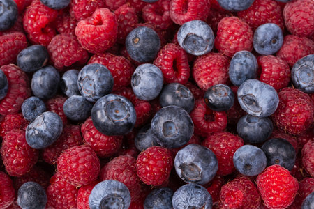 Raspberry, blueberry as a background. Top view.