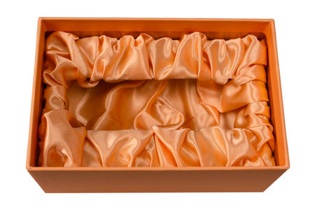 Orange empty gift box covered with orange satin fabric isolated on a white background. Top view.の写真素材