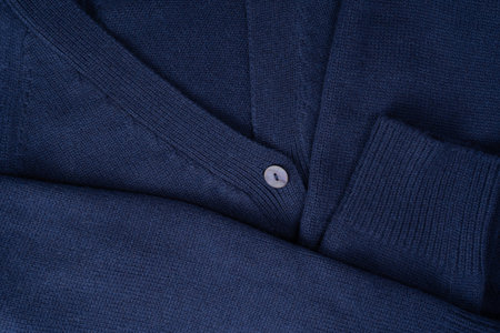 Navy blue merino wool cardigan texture as background. Top view.